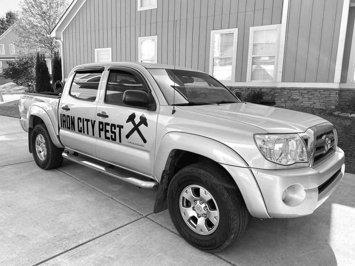 Iron City Pest Management's branded truck parked outside a Birmingham-metro home